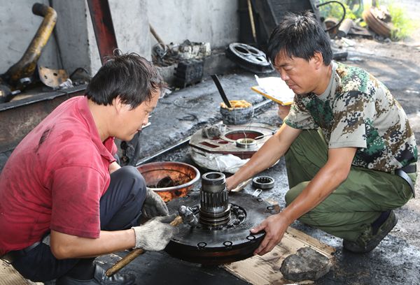 選運(yùn)區(qū)維修班班長(zhǎng)路續(xù)軒和工友對(duì)推土機(jī)變速箱部件進(jìn)行整形 選運(yùn)區(qū)維修班班長(zhǎng)路續(xù)軒和工友對(duì)推土機(jī)變速箱部件進(jìn)行整形